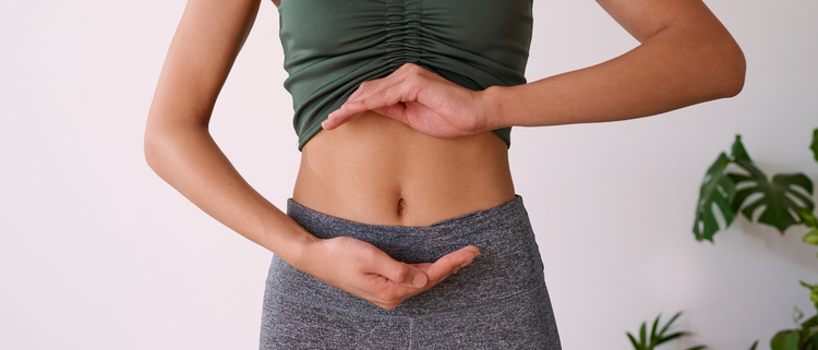 Blog of Ready to Heal Your Gut? How to Find the Best Gut Health Supplements For Your Microbiome which have image Close-up of a woman's midsection as she makes a hand gesture around her stomach, symbolizing gut health or digestion.