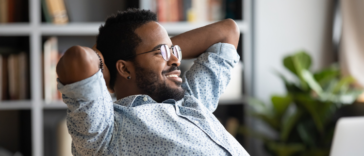 Blog of What Are the Best Supplements to Reduce Cortisol Naturally? which have image Smiling man relaxing with hands behind his head, sitting in a cozy home office.