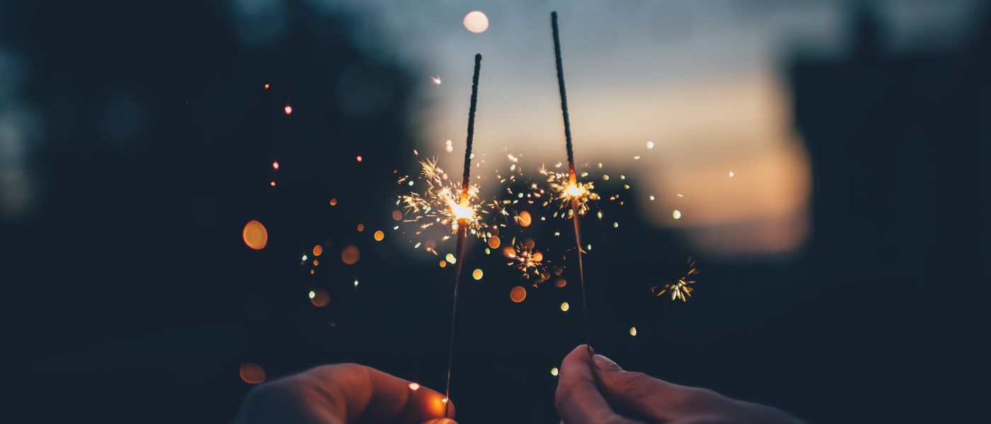 2 sparklers held up against a night sky