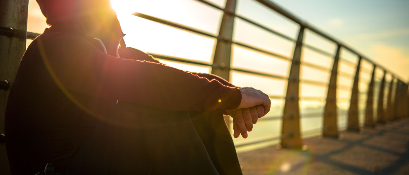 person sitting by a bridge