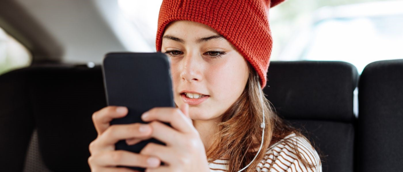 Girl in red hat sending a text