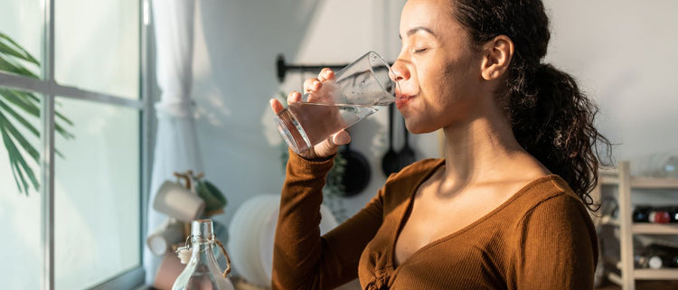 Blog of Water & Gut Health: Does Drinking Water Really Help Digestion? which have image woman drinking a glass of water