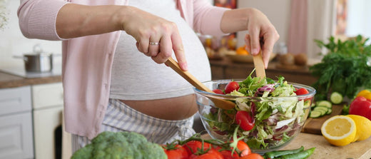 pregnant woman preparing a salad