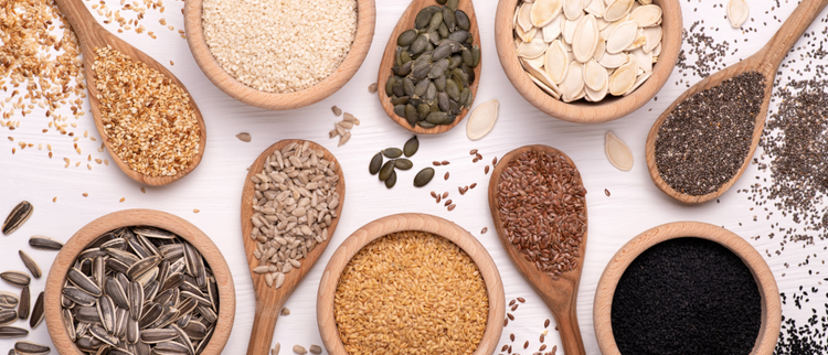Blog of Chia Seeds vs. Flax Seeds for Weight Management: Which Is More Effective? which have image An assortment of seeds, including sunflower, flax, sesame, pumpkin, and chia, displayed in wooden bowls and spoons on a white surface.